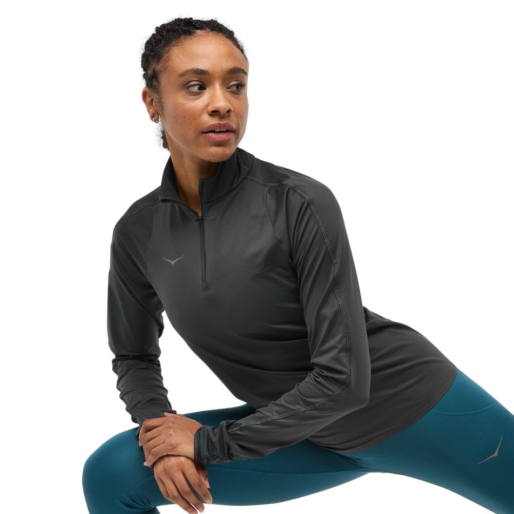 en model bærer en sort Hoka Glidetech Quarter Zip træningstrøje (dame)