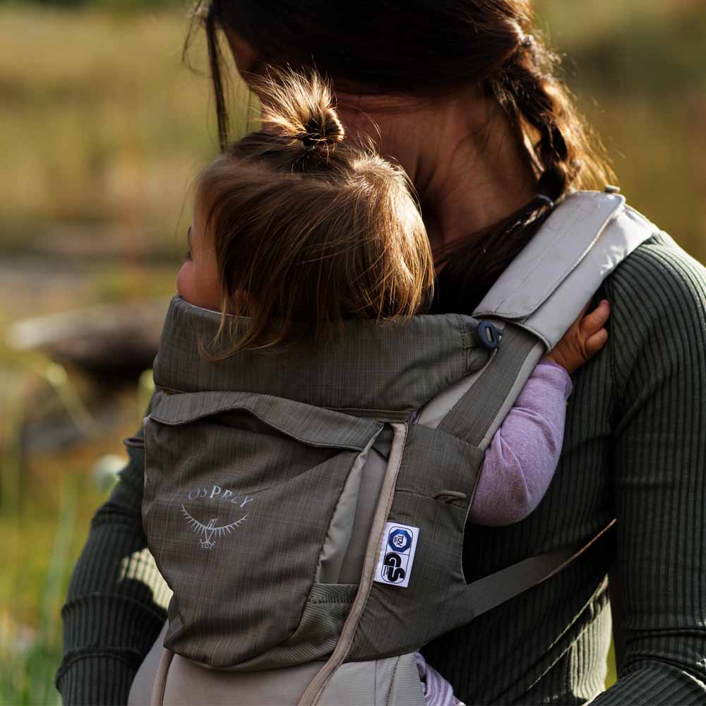 en model bærer et barn i Osprey Poco Soft Child Carrier bæresele (unisex)