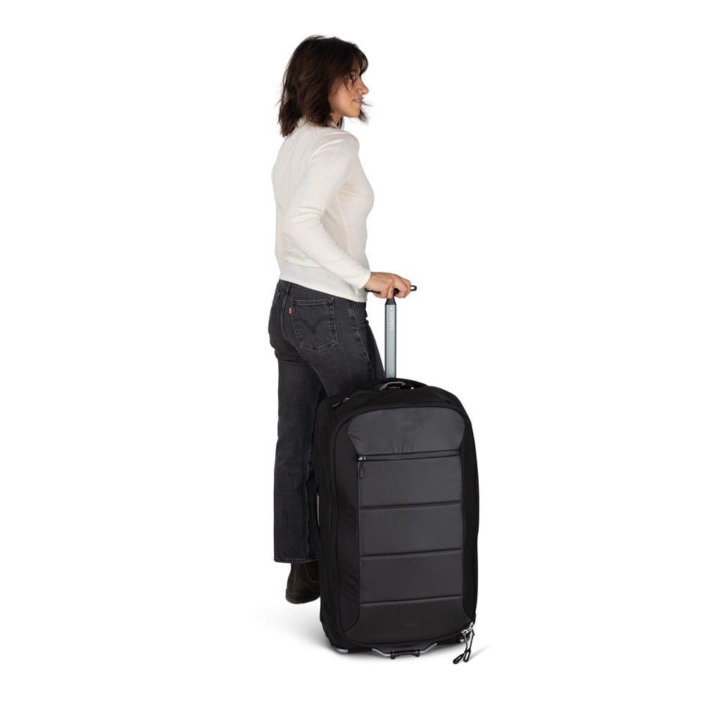 en kvinde bruger en Osprey Ozone 2-Wheel 80L kuffert (unisex)