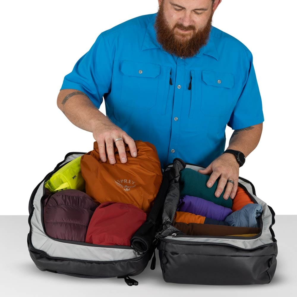 en person pakker en Osprey Transporter Squffel 44L taske (unisex)