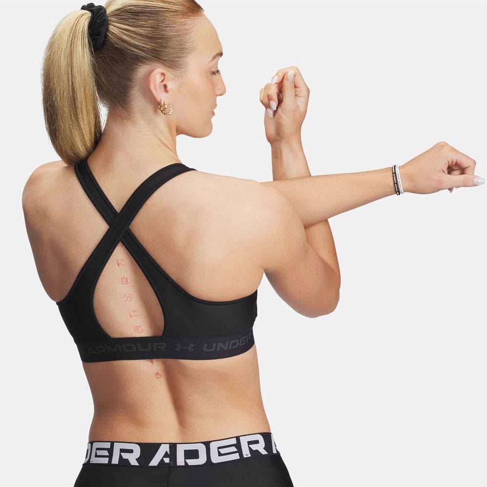 en model har Under Armour Cross Back Mid Bra sports-bh (dame) på