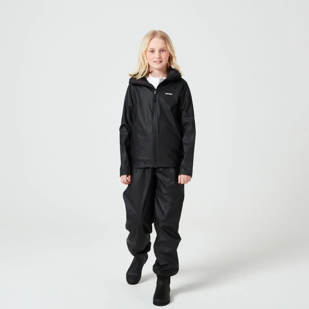 En pige har Tretorn Kids Packable rainset i jet black på