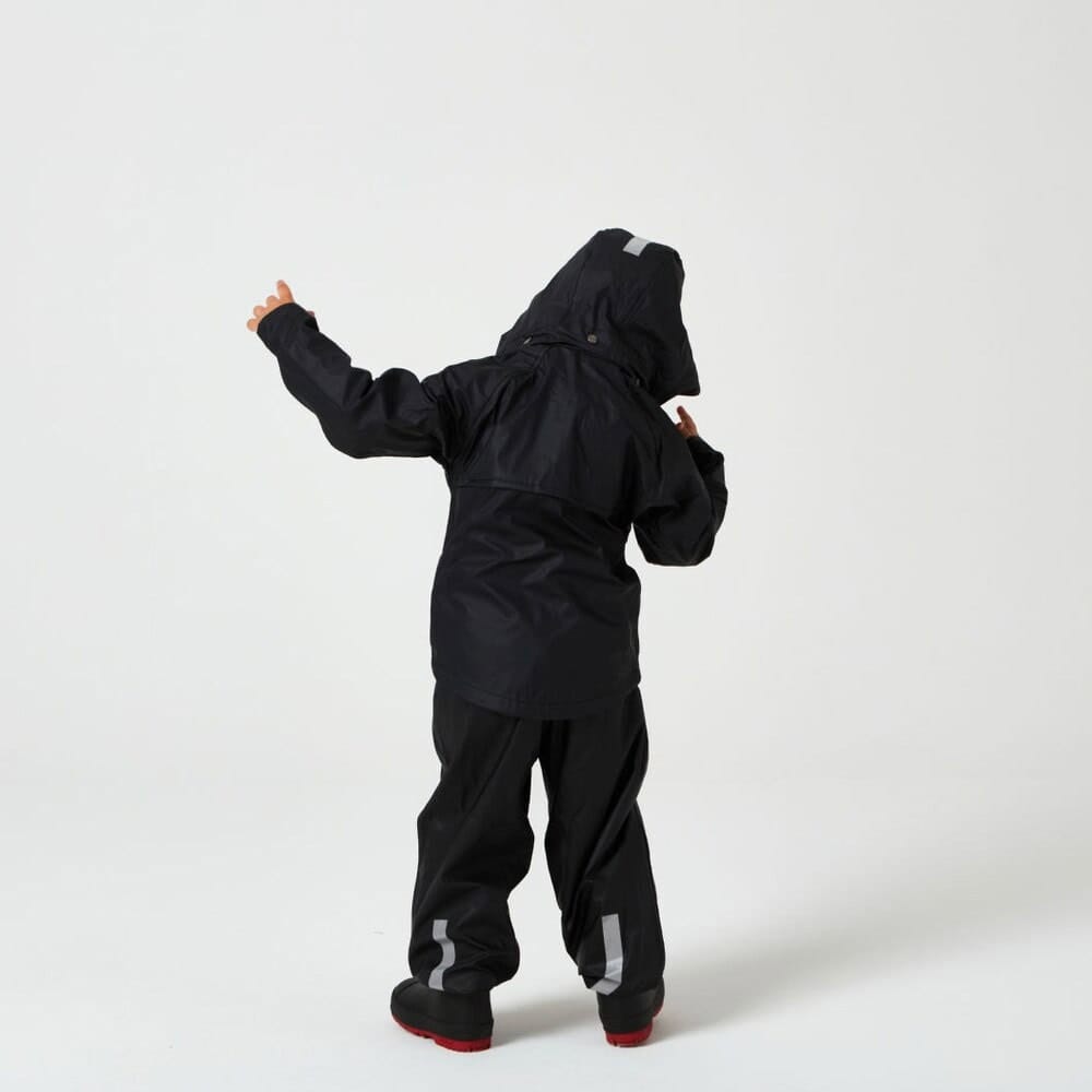 En dreng har Tretorn Kids Packable rainset på og står og danser