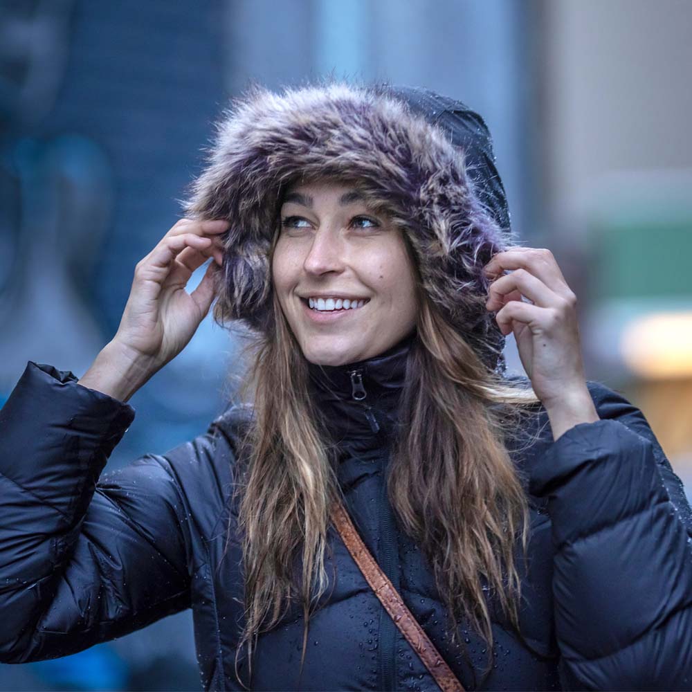 Udendørsbillede af kvinde iført Marmot Montreaux Coat med lodden hætte.