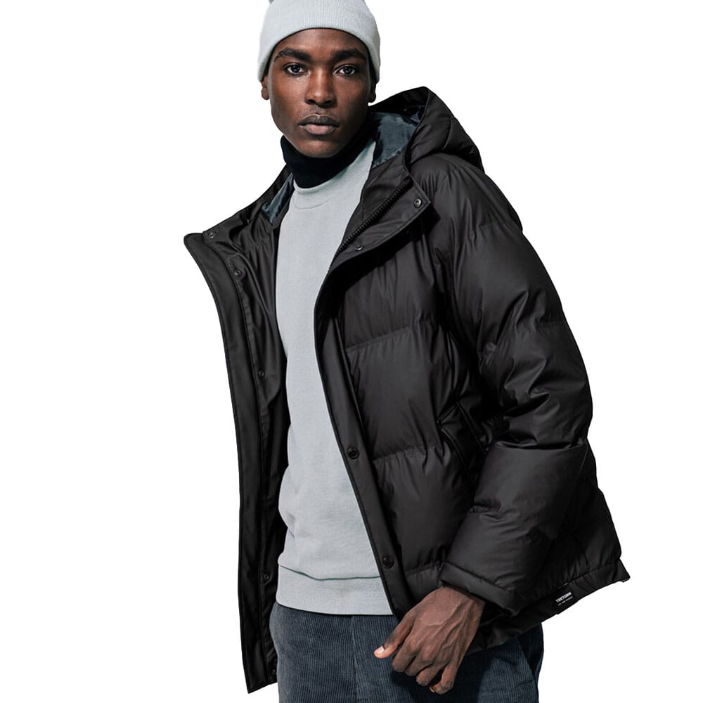 Mand iført Tretorn Baffle Jacket med hætte og høj krave.
