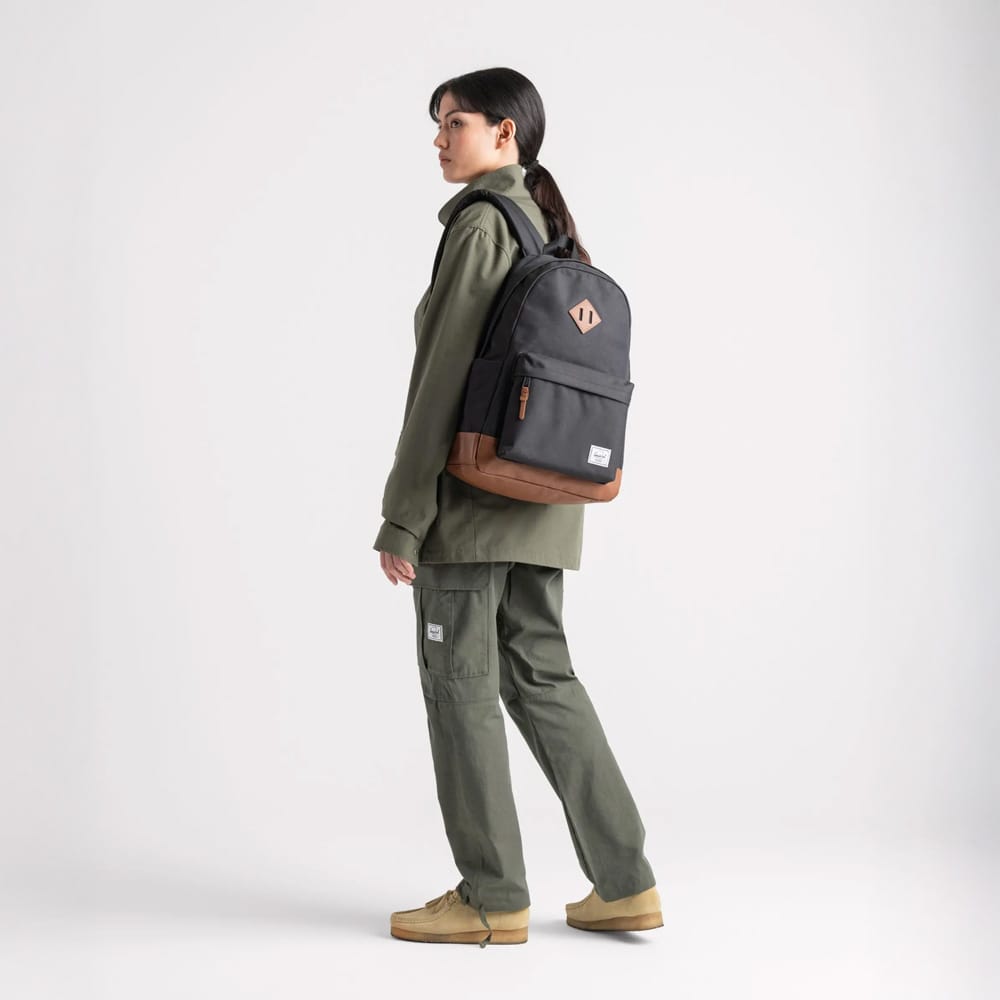 en kvindelig model bærer Herschel Heritage 24 L hverdagsrygsæk (unisex)