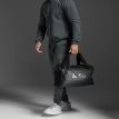 mies pitää 2XU Gym Bag treenilaukkua (unisex)