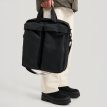 henkilö pitää Tretorn Wings Shoulder Tote laukkua (unisex) kädessään
