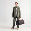 henkilö pitää kädessään Herschel Novel Duffle 43 L laukkua (unisex)