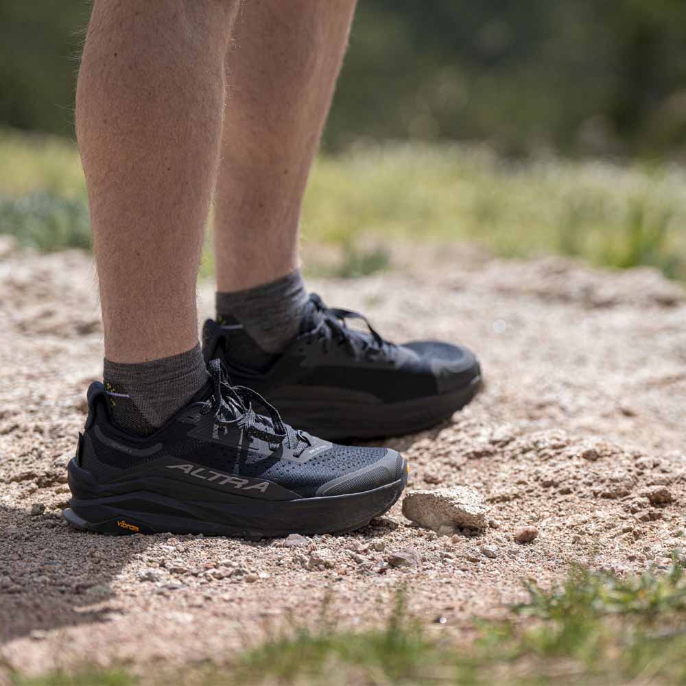 Altra Olympus 6 terrengløpesko (herre) i svart på en modell