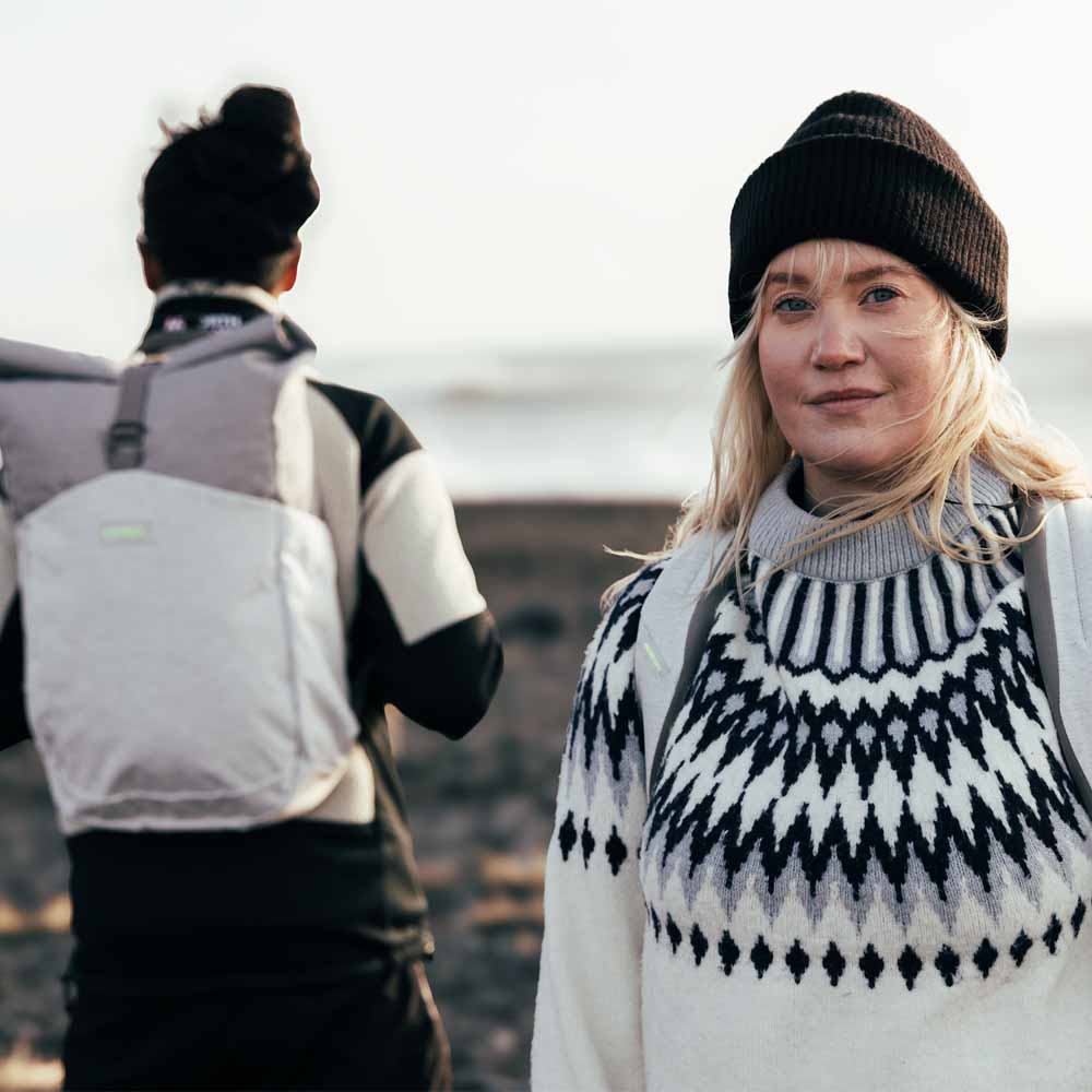 en modell bærer en Osprey Arcane Roll Top hverdagsveske (unisex)