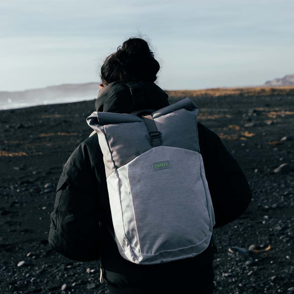 en modell bærer en Osprey Arcane Roll Top hverdagsveske (unisex)