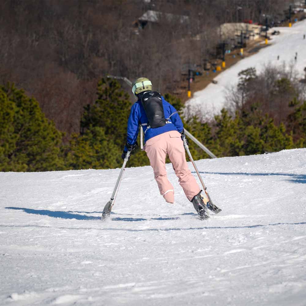en dame går på ski med Osprey Glade 20L skisekk (unisex) på seg