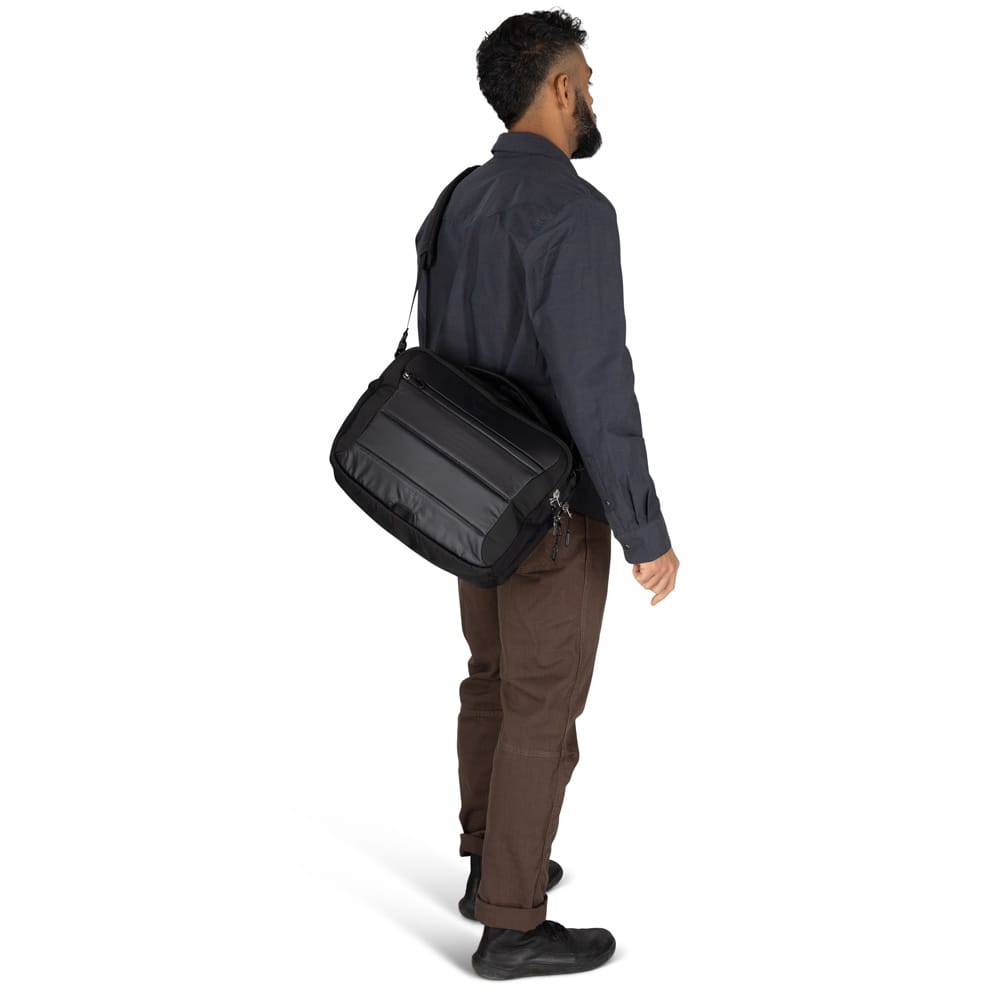 en mann bærer en Osprey Ozone Brief Bag datamaskinveske (unisex)