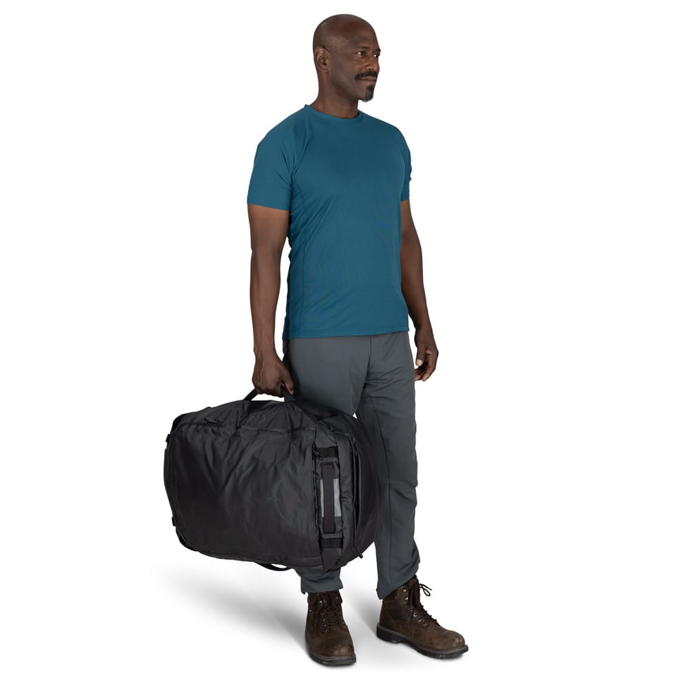 en mannlig modell bærer en Osprey Transporter Duffel 65L (unisex)