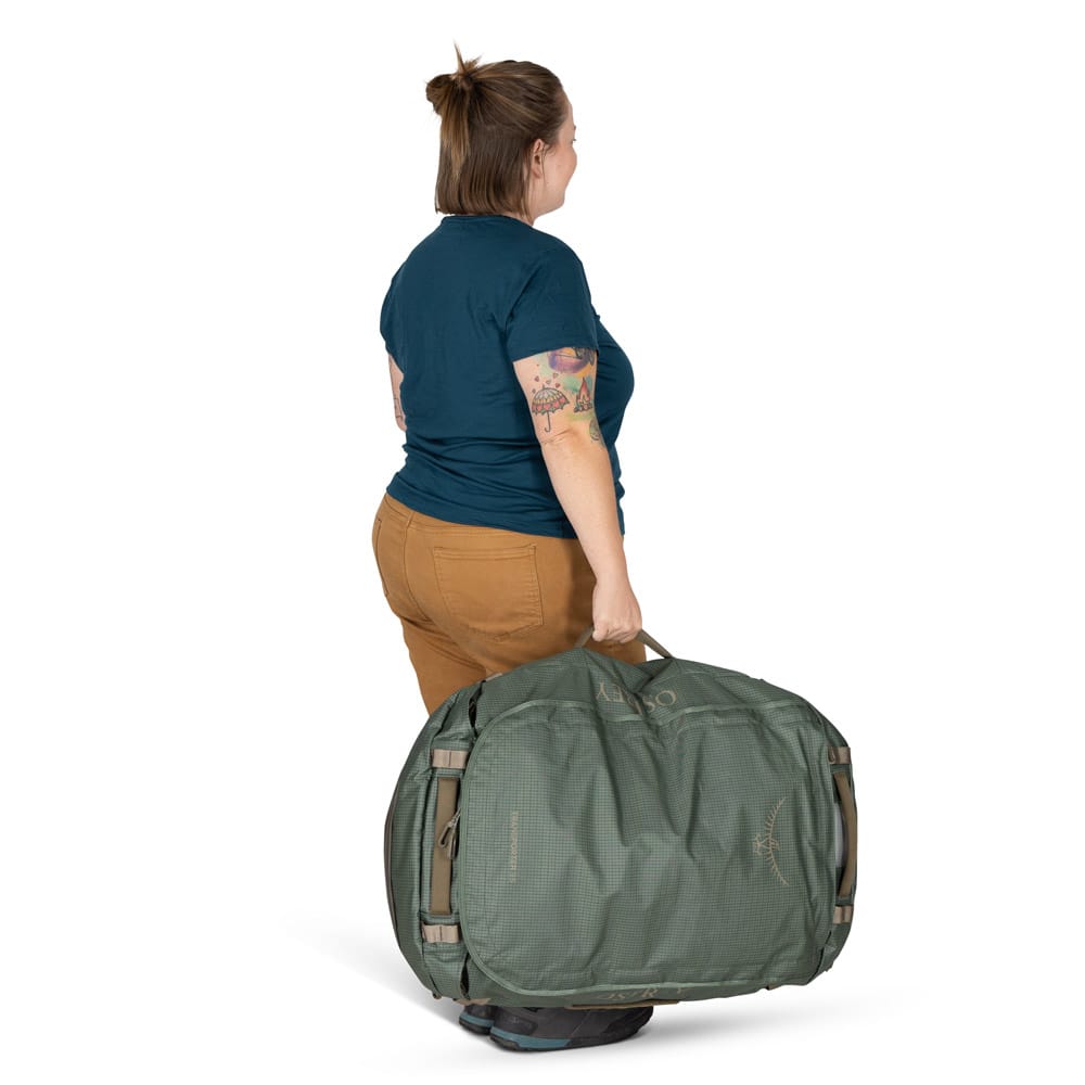 en kvinnelig modell bærer en Osprey Transporter Duffel 95L (unisex)