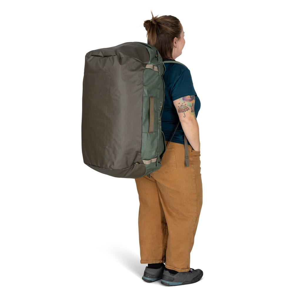en modell bærer Osprey Transporter Duffel 95L (unisex) som ryggsekk