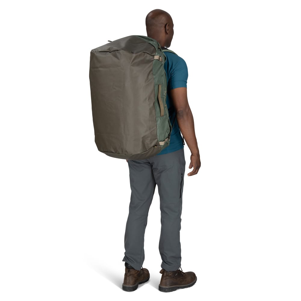 en mann bærer Osprey Transporter Duffel 95L (unisex) på ryggen
