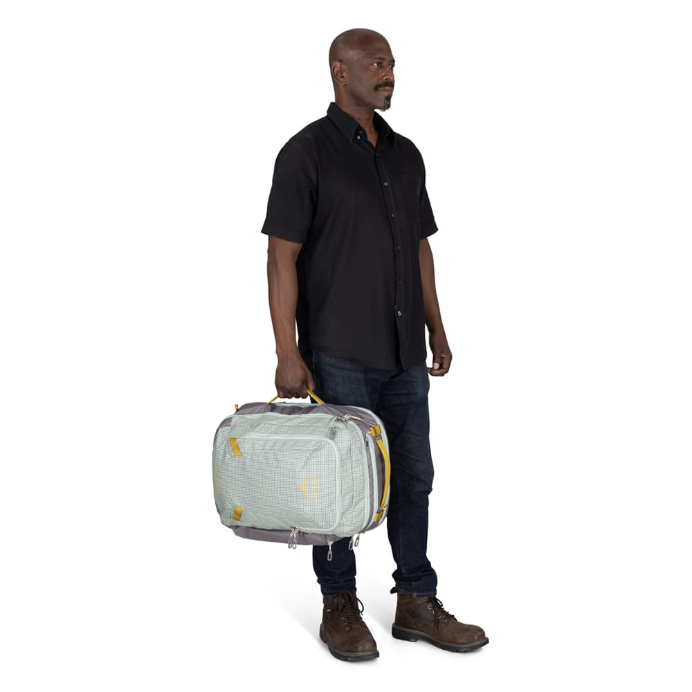 en modell bærer Osprey Transporter Travel Pack 36L reiseryggsekk (unisex) som en veske