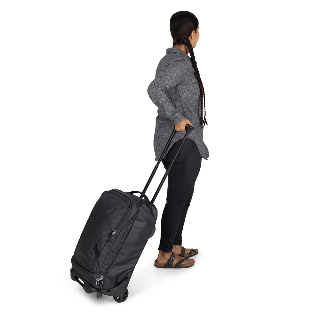 en kvinne holder i en Osprey Transporter Wheeled Carry-On reisekoffert 38L (unisex)
