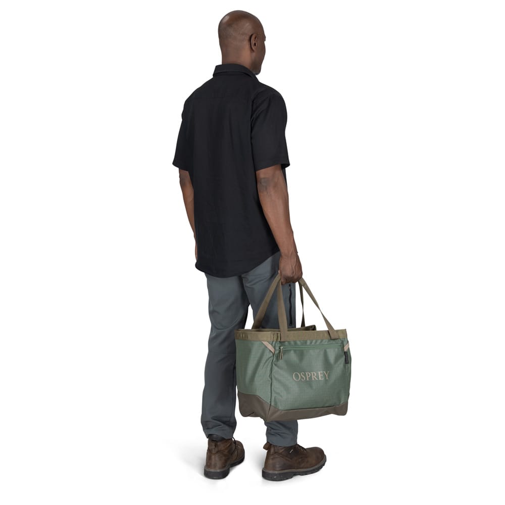 En mann bærer Osprey Transporter Gear Tote 28L veske (unisex)