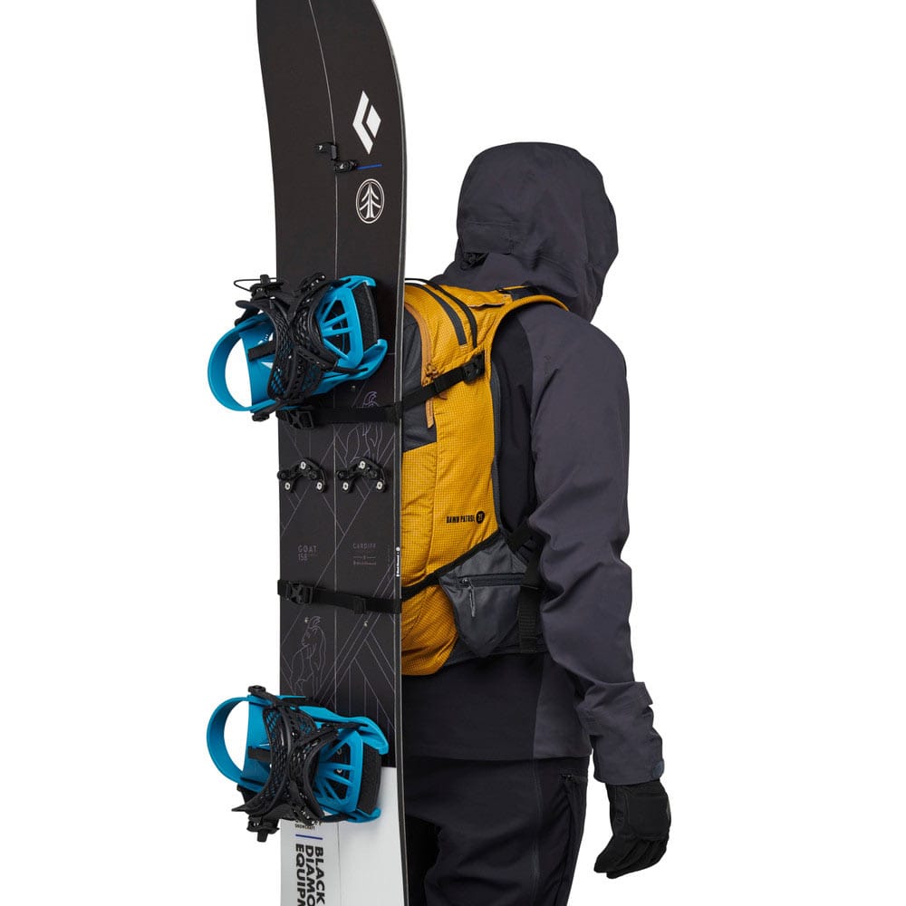 Mann som bærer Black Diamond Dawn Patrol 25 ryggsekk med snowboard