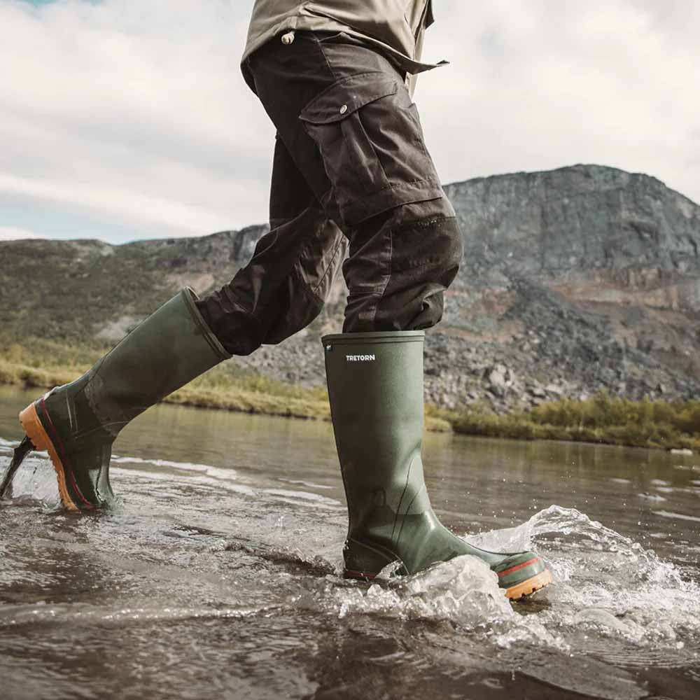Person som bruker høye Tretorn Sarek 72 klassiske gummistøvler (unisex).
